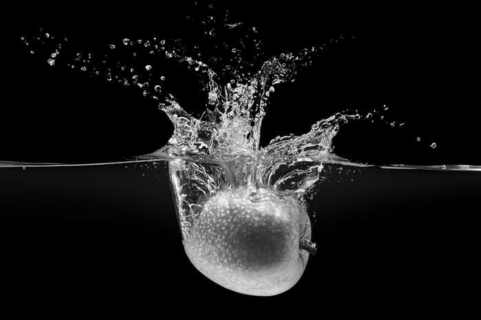 An apple dropping into water