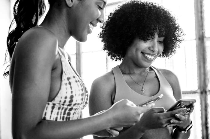Two people in training clothes looking at a phone together