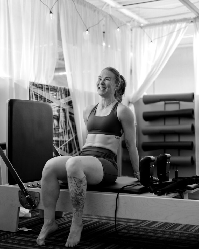 A member laughing between exercises on a reformer